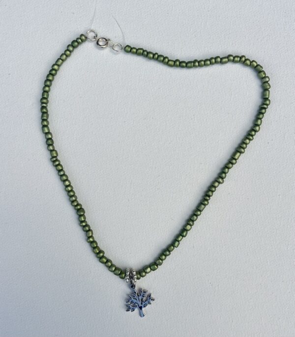 Small metallic green beaded necklace with a small silver tree of life pendent