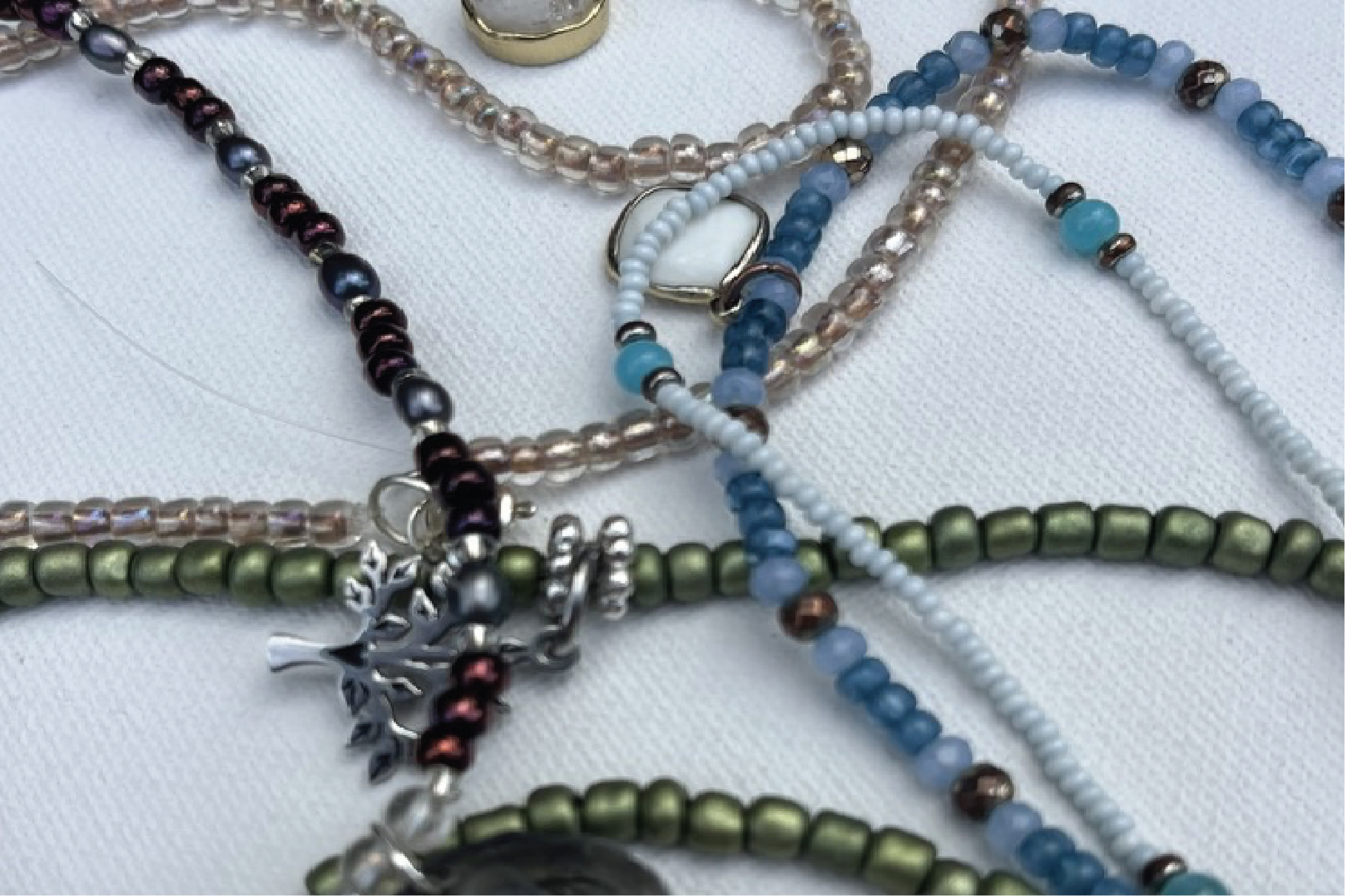 Close up bundle of four pieces of beaded jewelry