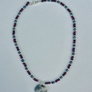 Small dark blue and purple beaded necklace with grey iridescent shell pendant